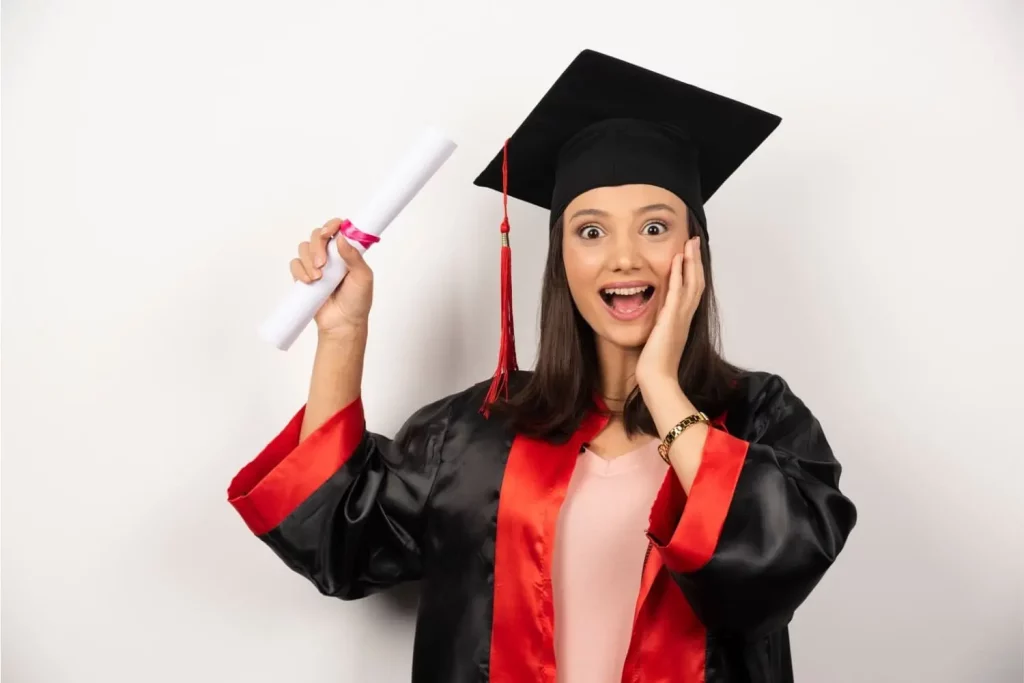 Une jeune fille diplômée et heureuse qui tient son diplôme entre les mains