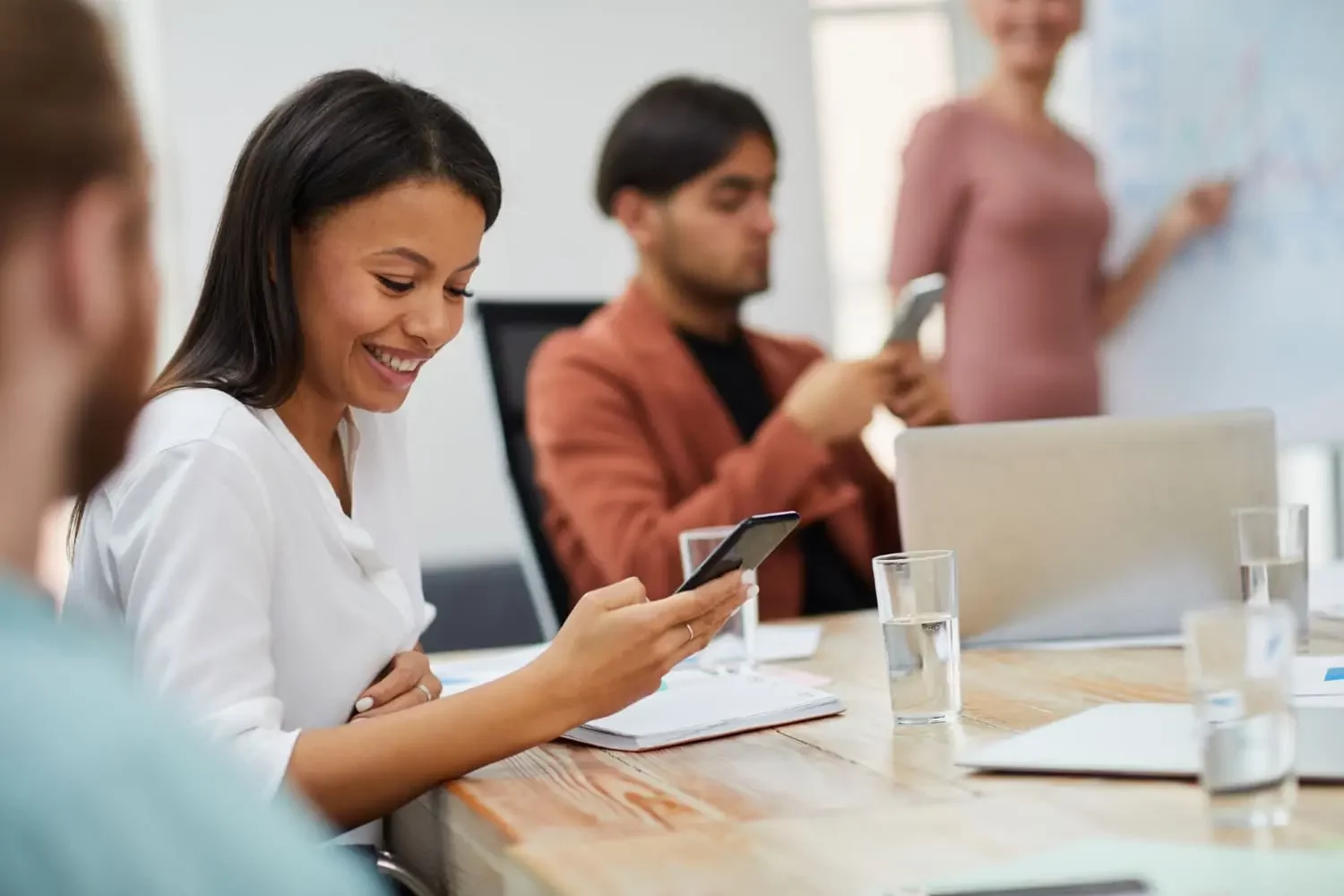 Une jeune fille qui sourit en regardant son téléphone pendant un cours au centre de formation