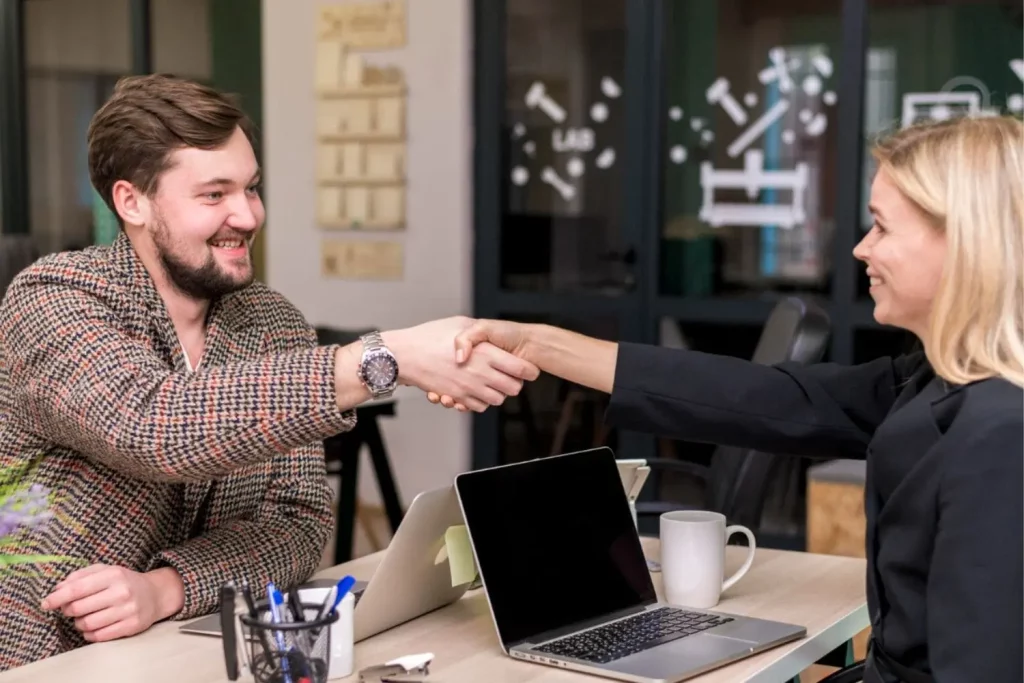 Une poignée de main entre une femme professionnelle et son client dans un bureau