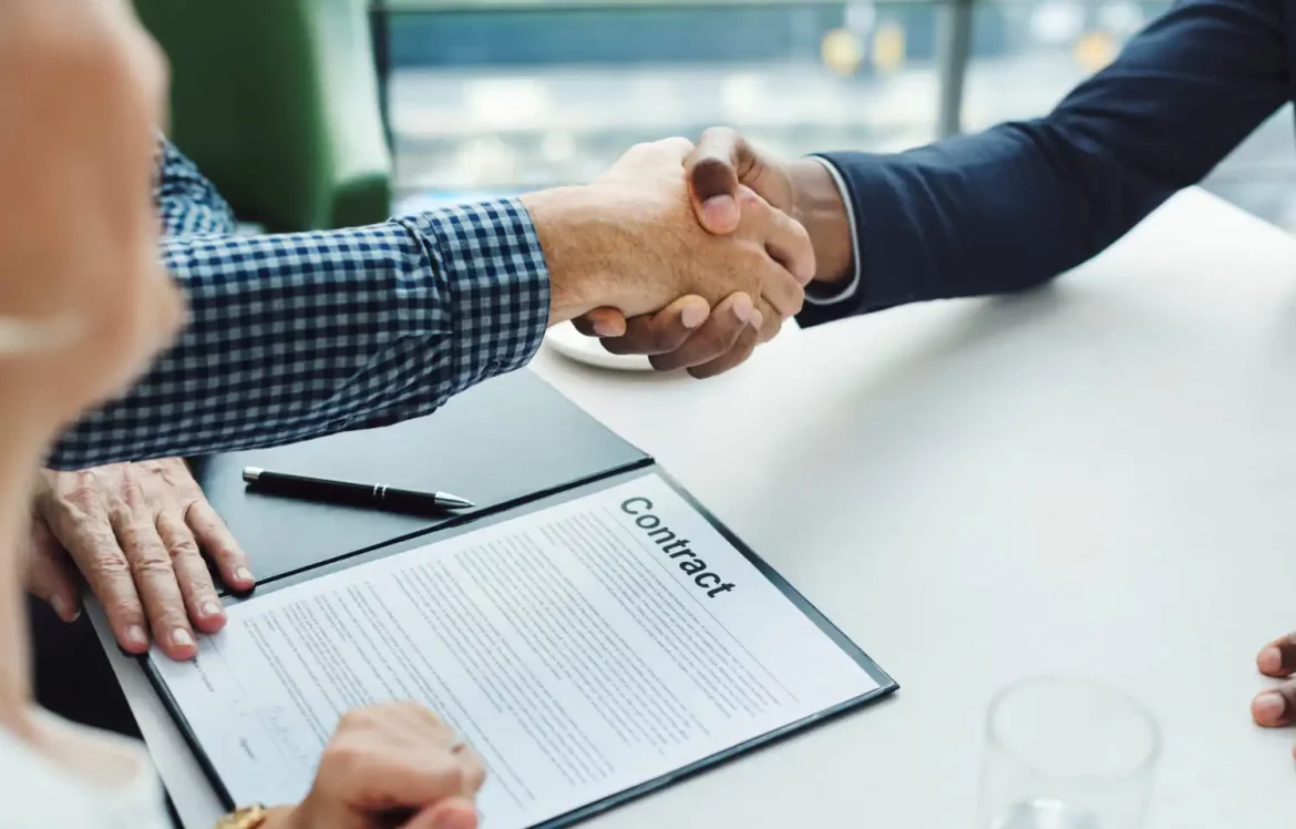 Deux personnes qui se serrent la main après la signature d'un contrat