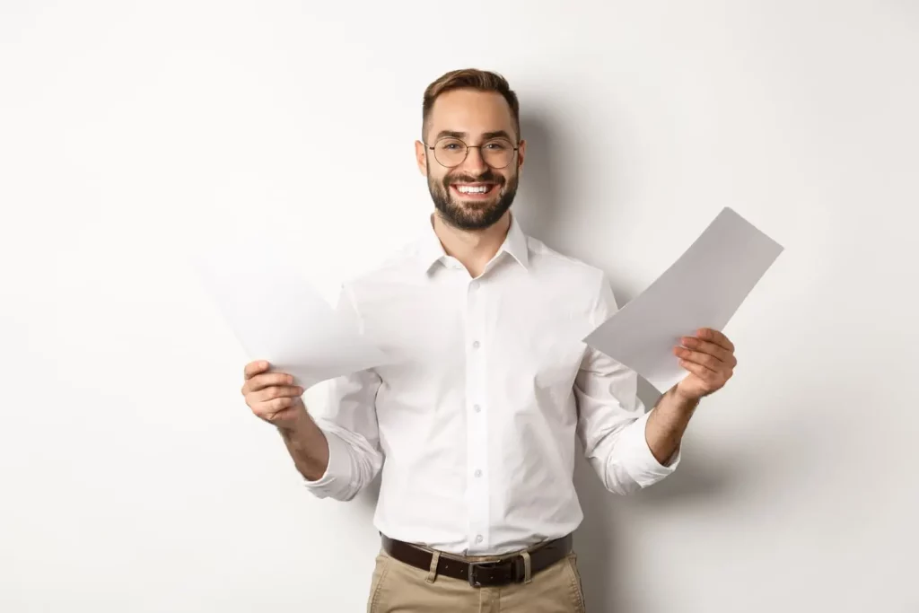 Une homme avec des documents dans la main gauche et d'autres documents dans la main droite