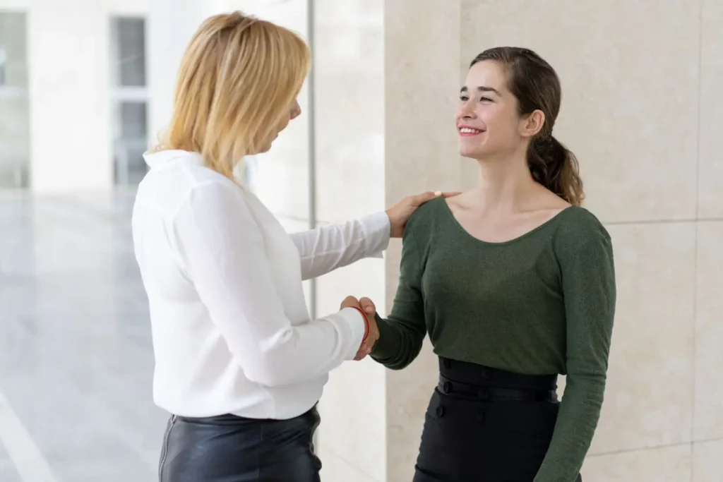 Un tuteur accueille une nouvelle étudiante en alternance avec le sourire