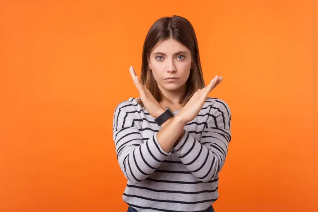 Une femme qui fait un croix avec les mains pour signaler une erreur ou quelque chose à éviter
