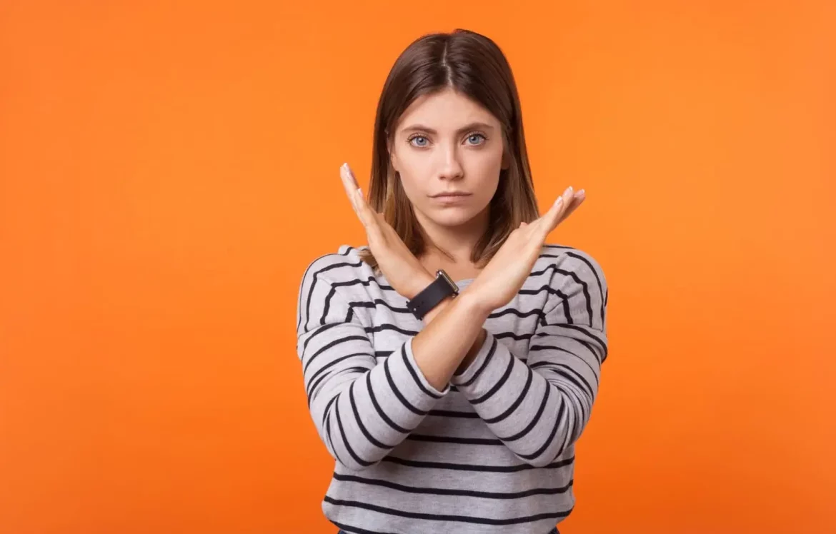 Une femme qui fait un croix avec les mains pour signaler une erreur ou quelque chose à éviter
