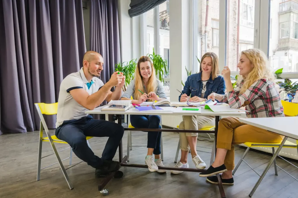 Un groupe de 4 jeunes qui discutent autour de la table au travail
