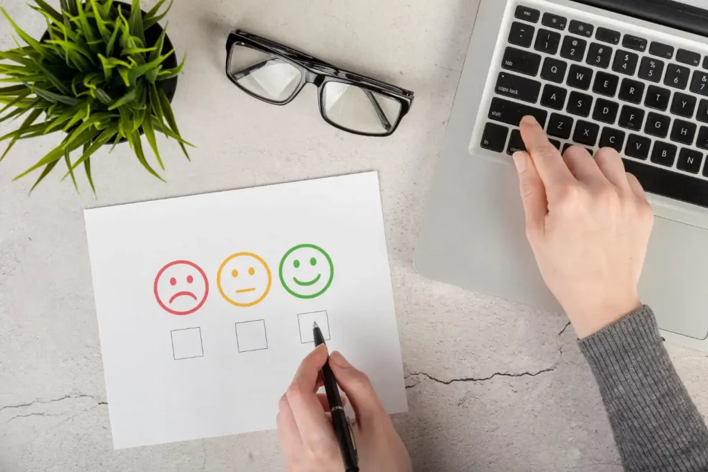 Choisir entre un smiley rouge, jaune et vert sur une feuille en guise d'évaluation