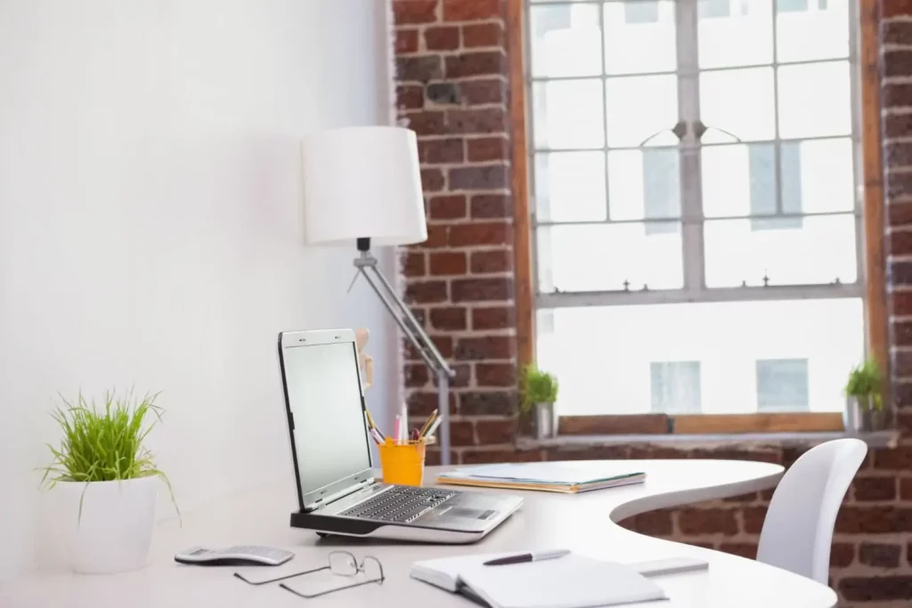 Bureau avec un ordinateur, une lampe et des documents