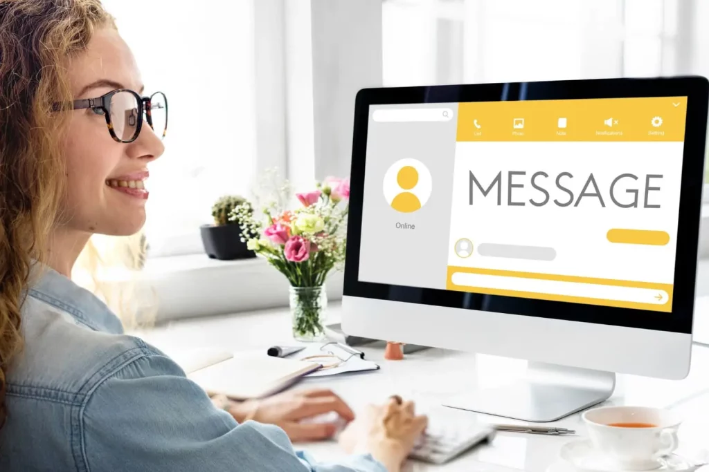 Une femme devant l'écran de son ordinateur portable qui affiche des messages