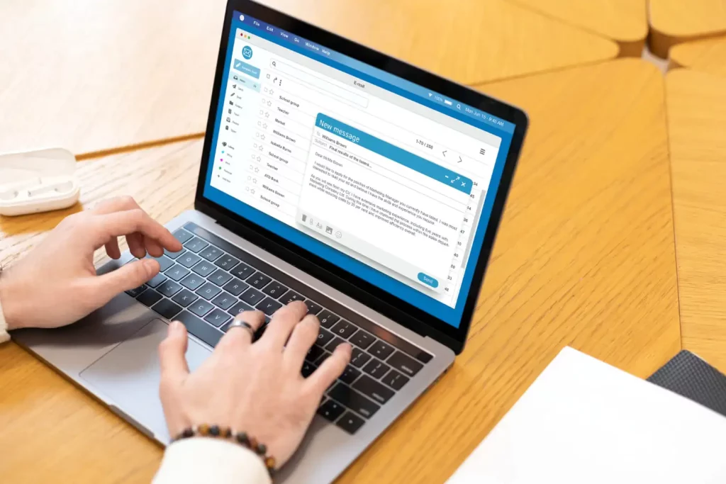 Une personne répond à des mails sur un ordinateur portable
