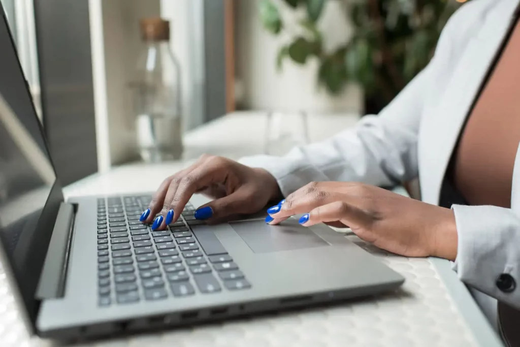 Les mains d'une femme qui tape sur le clavier d'un ordinateur portable