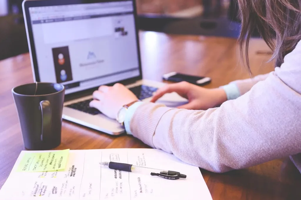 Une personne prend des notes pour préparer son cv